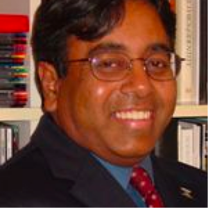A person wearing glasses and a suit.